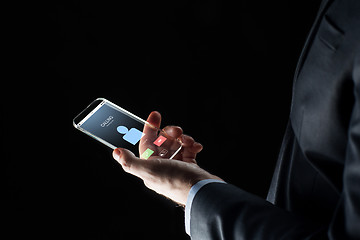 Image showing close up of hand with incoming call on smartphone