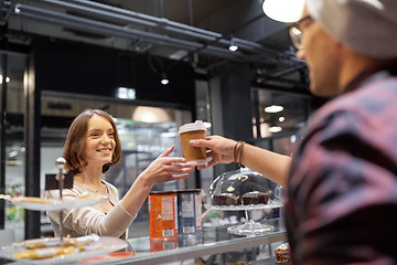 Image showing seller giving coffee cup to woman customer at cafe