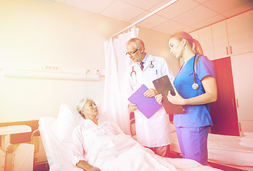 Image showing doctor and nurse visiting senior woman at hospital