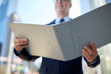 Image showing senior businessman with ring binder folder in city