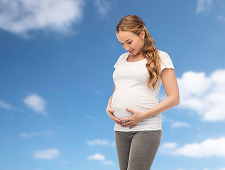 Image showing happy pregnant woman touching her big belly