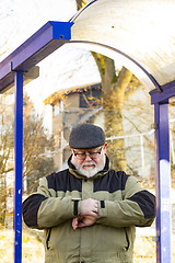 Image showing Male senior looks at his watch