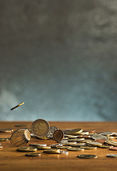 Image showing The silver and golden coins and falling coins on wooden background