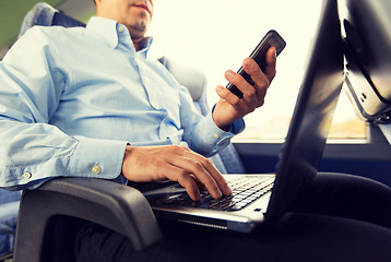 Image showing man with smartphone and laptop in travel bus