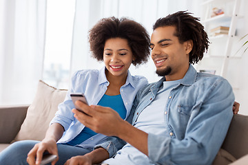 Image showing happy couple with smartphones at home