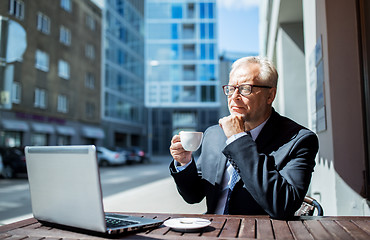 Image showing senior businessman with laptop drinking coffee