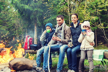 Image showing happy family sitting on bench at camp fire