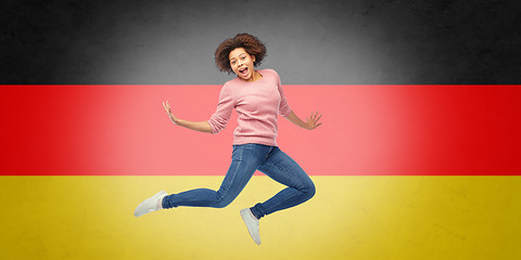 Image showing african american woman jumping over german flag