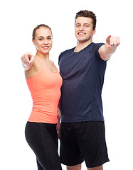 Image showing happy sportive man and woman pointing finger