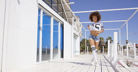 Image showing Smiling female standing near white building