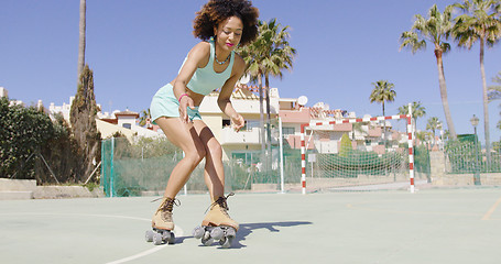 Image showing Young pretty woman riding in roller skates