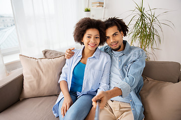 Image showing happy couple with selfie stick at home