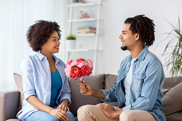 Image showing happy couple with bunch of flowers at home