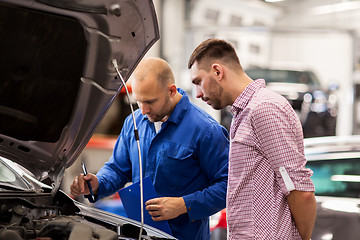 Image showing auto mechanic with clipboard and man at car shop