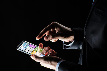 Image showing close up of businessman with apps on smartphone