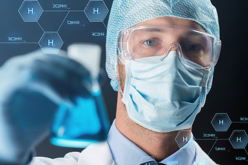 Image showing close up of scientist holding flask with chemical