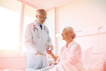 Image showing doctor giving medicine to senior woman at hospital