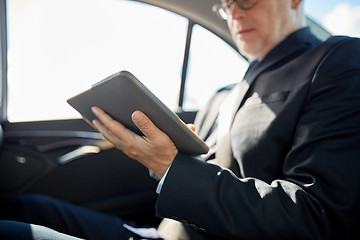 Image showing senior businessman with tablet pc driving in car