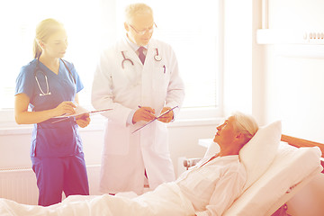 Image showing doctor and nurse visiting senior woman at hospital