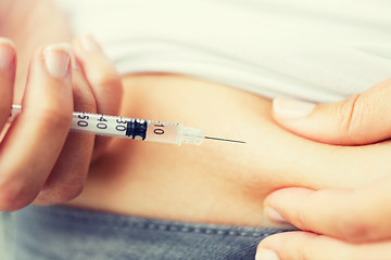 Image showing woman with syringe making insulin injection