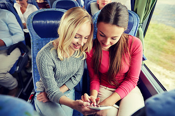 Image showing happy young women in travel bus with smartphone