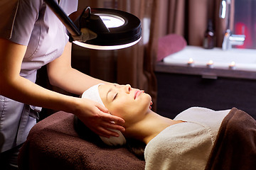 Image showing beautician doing face massage to woman at spa