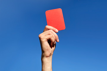 Image showing referee hands with red card on football field