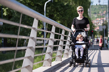 Image showing mother pushed her baby daughter in a stroller