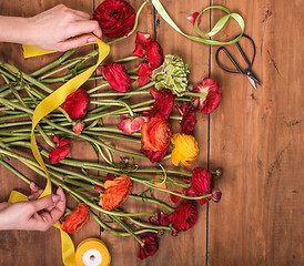 Image showing Ranunkulyus bouquet of red flowers on a wooden background