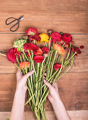 Image showing Ranunkulyus bouquet of red flowers on a wooden background