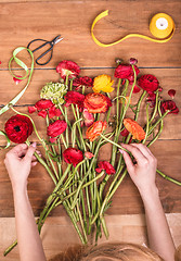 Image showing Ranunkulyus bouquet of red flowers on a wooden background