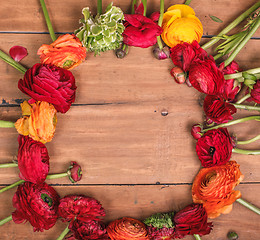 Image showing Ranunkulyus bouquet of red flowers on a wooden background