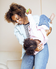 Image showing adorable sweet young afro-american mother with cute little daughter, hanging at home, having fun playing smiling, lifestyle people concept, happy smiling modern family 