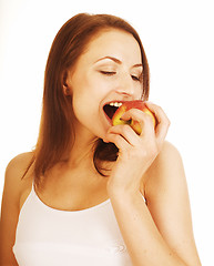 Image showing young pretty brunette girl eating red apple isolated on white