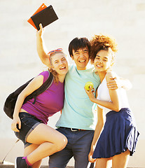 Image showing cute group of teenages at the building of university with books huggings