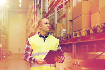 Image showing man with clipboard in safety vest at warehouse