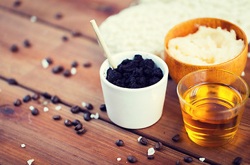 Image showing close up of coffee scrub in cup and honey on wood