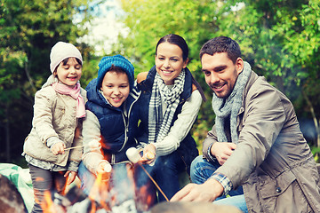 Image showing happy family roasting marshmallow over campfire