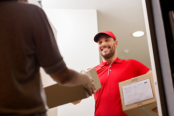 Image showing happy delivery man giving parcel box to customer