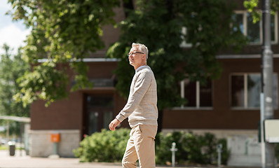 Image showing senior man walking along summer city street