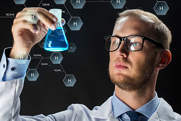 Image showing young scientist holding test flask with chemical