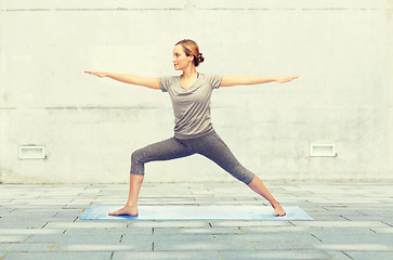 Image showing woman making yoga warrior pose on mat