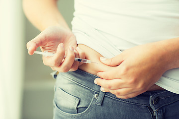 Image showing woman with syringe making insulin injection