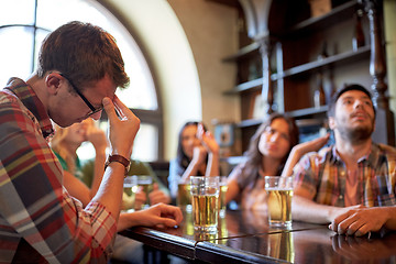 Image showing friends with beer watching football at bar or pub