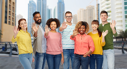 Image showing international group of people waving hand in city