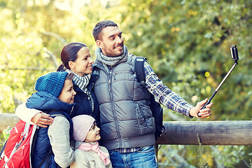 Image showing happy family with smartphone selfie stick in woods