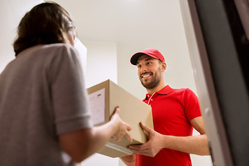 Image showing happy delivery man giving parcel box to customer