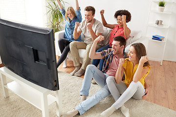 Image showing happy friends with remote watching tv at home