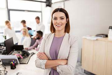 Image showing happy young woman over creative team in office