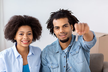 Image showing happy couple with key and boxes moving to new home